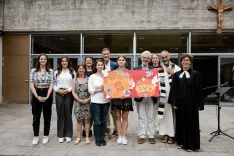 Class photo in which the Bishop's Gymnasium Paulinum holds up a poster displaying the donation result.