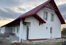 Helles, neues Haus des Lächelns mit rotem Dach, freundlich und einladend, noch im Bau.